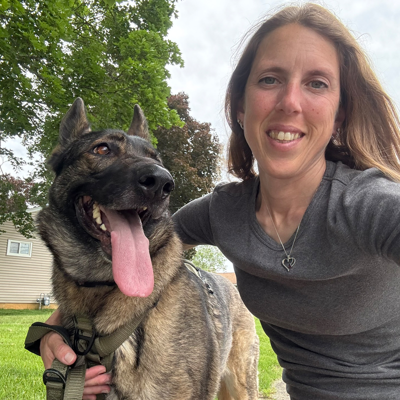 Regina walking a happy German Shepherd on a neighborhood visit