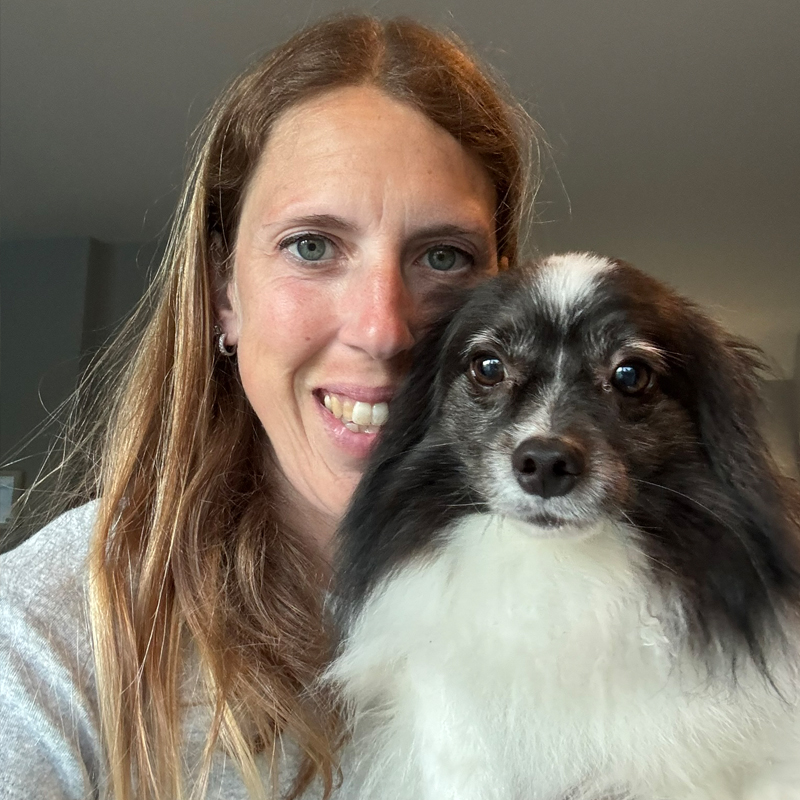 Regina cuddling with a dog during pet sitting drop-in