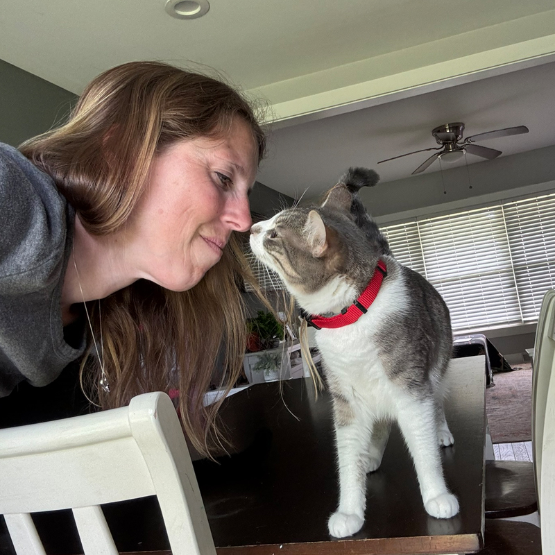 Regina giving nose kisses to a relaxed orange cat