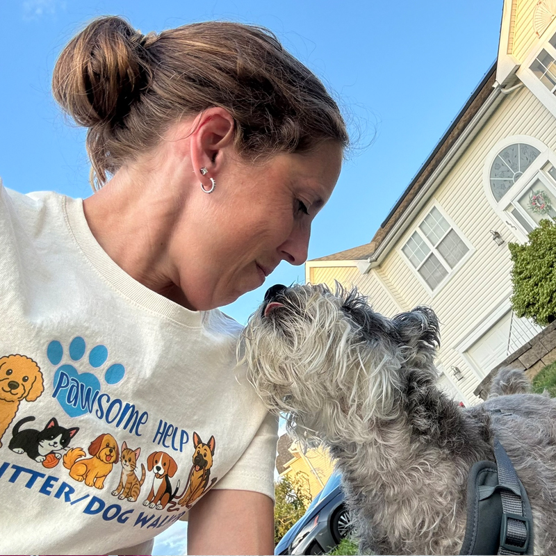 Regina giving nose kisses to a dog she is taking on a dog walk